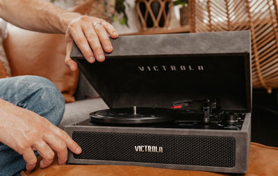 Man's hands opening Victrola player case